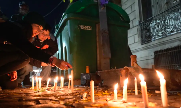 Varias personas encienden velas durante una vigilia el 8 de mayo de 2024, frente a la casa donde tres mujeres lesbianas fueron asesinadas tras un ataque en Buenos Aires. © 2024 Juan Mabromata/AFP via Getty Images