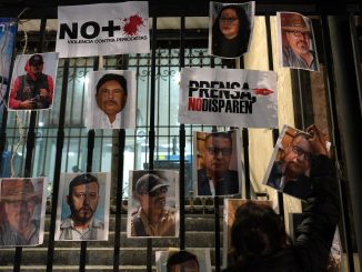 Una mujer coloca una foto de un periodista asesinado durante una manifestación contra la violencia hacia la prensa, el 25 de enero en Ciudad de México. EDUARDO VERDUGO (AP)